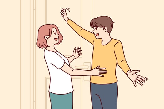 Happy couple embraces at meeting near entrance to house and rejoices at long-awaited date. Man returns from business trip and hugs wife or girlfriend, rejoicing in date after long separation.