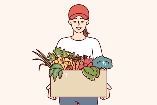 Woman farmer holds box of vegetables and fruits, offering to buy organic food at bargain price. Girl courier delivers eco vegetables grown without use of pesticides and fertilizers