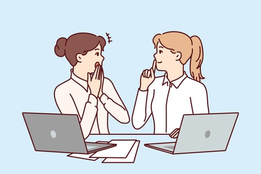 Woman office workers gossip and share secret forbidden for distribution, sitting at table with laptops and papers. Girls gossip and make shh sign forbidding data dissemination due to NDA contract