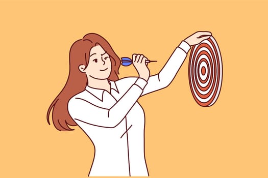 Woman holds dart board and hits target, showing leadership and ambition in achieving plans. Business girl in white shirt strives to fulfill target for career growth and life success.