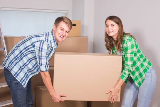 Happy young couple unpacking or packing boxes and moving into a new home