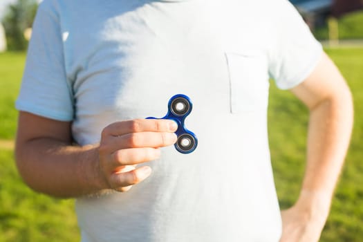 Man hand holding popular fidget spinner toy.