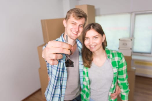 Happy couple embracing and showing house key in their new home