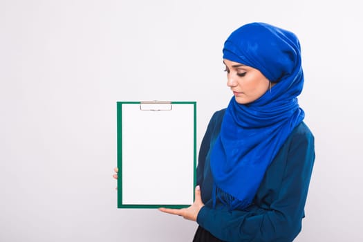 Your text here. Pretty young excited Arab woman holding empty blank board. Colorful studio portrait with white background