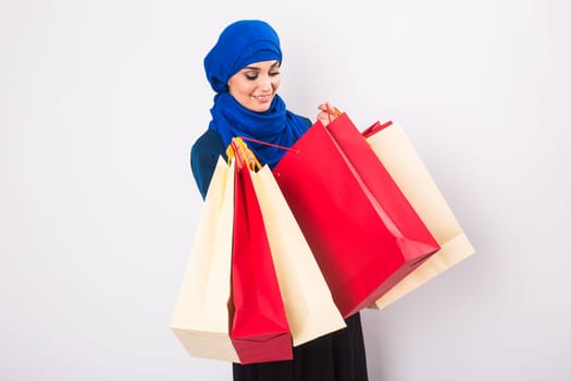 Arab or Muslim woman with shopping bags on white background