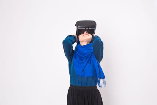 Woman with virtual reality goggles. Studio shot, gray background