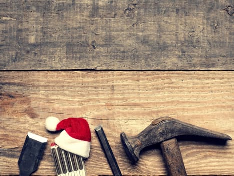 Old used carpenter tools with the hat of Santa, industrial Christmas background with space for text or image