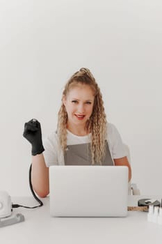 Woman Professional Manicurist at her Desk Works with a Laptop. Sign up for manicure Services, Freelancer Work Schedule.