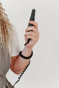 Woman nails artist holding manicure machine in her hand. White background.