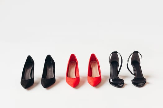 Red and black women's shoes with high heels on white background. Female classic stiletto heels in suede leather