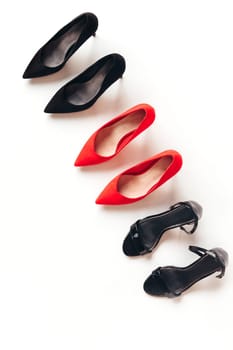 Red and black women's shoes with high heels on white background. Female classic stiletto heels in suede leather. Top view