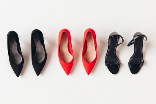 Red and black women's shoes with high heels on white background. Female classic stiletto heels in suede leather. Top view