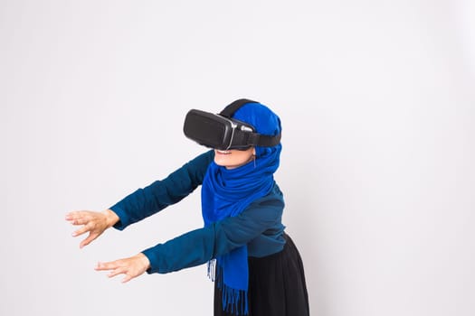 Woman with virtual reality goggles. Studio shot, gray background