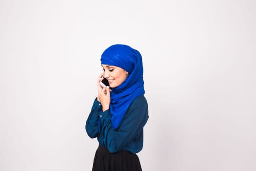 young muslim woman in head scarf using phone