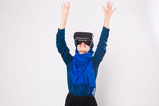 Asian muslim woman wearing hijab using VR headset glasses of virtual reality on white background