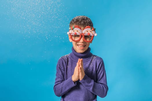 Child boy throws up on blue background. Christmas and New Year holidays concept. Generation alpha and gen alpha children. Copy space.