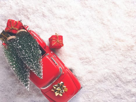 Red Christmas truck with Christmas trees and gift boxes in the snow, view from above, space for your text on the left side