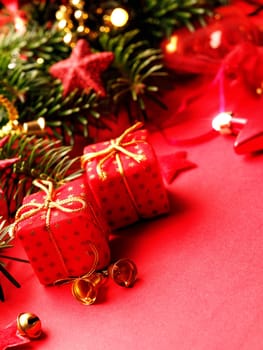 Traditional Christmas background with twigs of a fir tree and red Christmas decoration, selective focus on the foreground