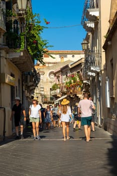Taormina, Sicily, Italy - 28 September 2023. Tourists on the busy streets of the old town of Taormina in cafes and restaurants. City views, facades, architecture and the most popular streets.