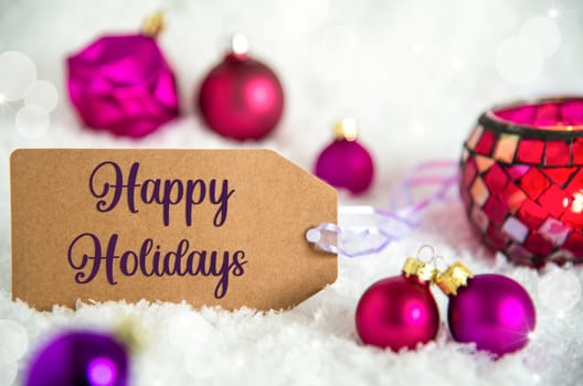 Label With Text Happy Holidays, White Snow Background With Purple Christmas Balls, Christmas And Winter Decor