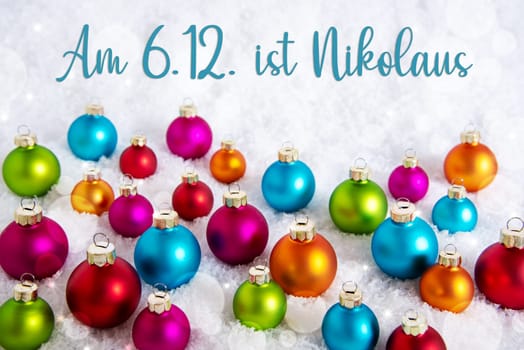 German Text Am 6.12. Ist Nikolaus, Means Happy Nikolaus Dec 6th In English, On White Snow, With Many Colorful Christmas Balls, Winter Background