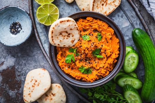 Homemade vegan Harissa carrot and lentil spread or dip with flatbread and cucumber