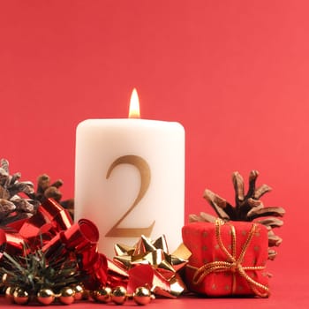 Second Advent candle burns, white candle with the number two on a red background, Christmas decoration, space for text