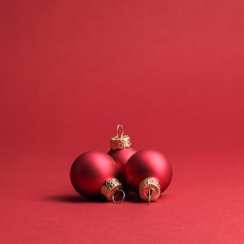 Three red vintage Christmas baubles on a red background with space for your text or image, seasonal holiday concept