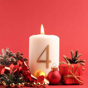 Fourth Advent candle burns, white candle with the number four on a red background, Christmas decoration, space for text