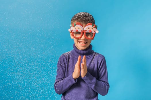 Child boy throws up on blue background. Christmas and New Year holidays concept. Generation alpha and gen alpha children. Copy space.