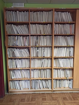 Shelf with archival documents. Lots of papers. pile of archive papers. Old Card file with information about clients. Piles of paper on the shelves