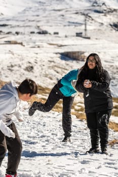 latin people, throwing snowballs at a ski resort in granada, sierra nevada, andalucia, spain.