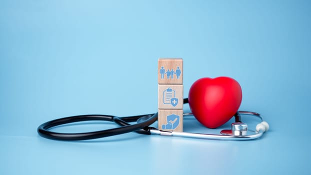 The concept of health insurance and medical welfare. Block wooden and red heart with plus icon. Health insurance and access to health care.