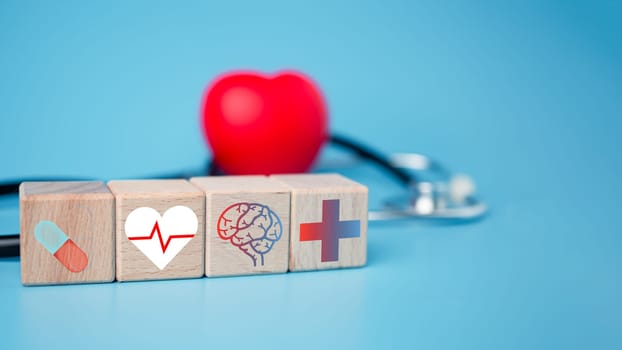 The concept of health insurance and medical welfare. Block wooden and red heart with plus icon. Health insurance and access to health care.