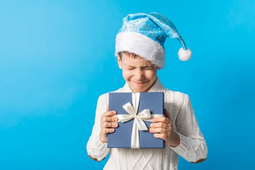 Child boy gift. Kid in blue christmas hat holds gift box. Shopping time. Banner header with copy space. Generation alpha and gen alpha