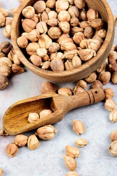 White cardamom in a wooden mortar, spice on a wooden rustic background.