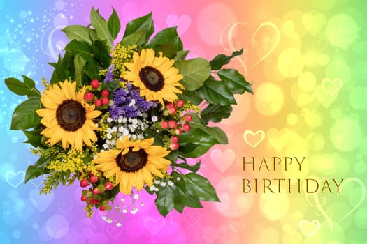 Happy birthday card design with a gorgeous blooming bouquet of sunflowers on a bright abstract rainbow background with bokeh hearts.