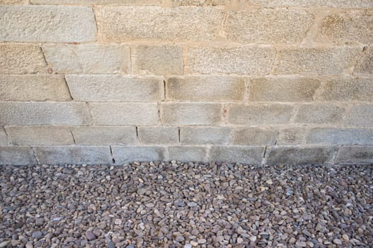 Granite ashlars wall with river pebble stones as ground. Flooring techiques for drainage