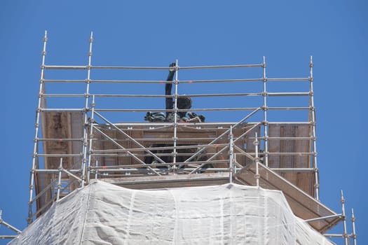 Cornice sculpture covered with scaffoldings. Heritage preservation concept