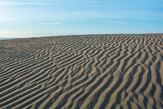 Lines in the desert sand with blue sky