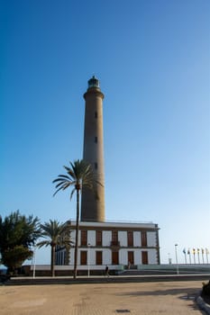 Lighthouse in Maspalomas ( Faro de Maspalomas ) on the Canary Island of Gran Canaria in Spain with palm tree