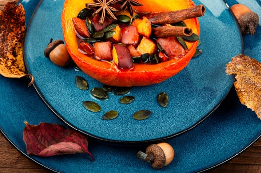 Tasty pumpkin baked with apples, peaches and cinnamon. Autumn recipe, baked squash. Healthy food