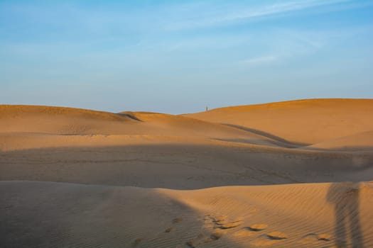 In the dunes of Maspalomas on Gran Canaria in Spain. With a Lighthouse. The huge sand dunes resemble a small desert and are a nature reserve.