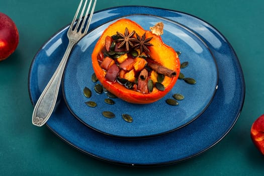Tasty pumpkin baked with apples, peaches and cinnamon. Autumn recipe, baked squash. Healthy food