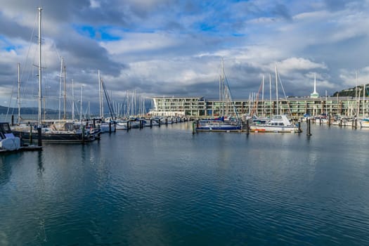 Wellington, New Zealand - 12 May 2023: Wellington Harbour with sailing boats moored at wooden bollards. Wellington, New Zealand.