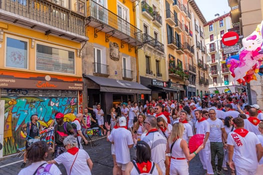 Pamplona, Spain: 09 July 2023: People celebrate San Fermin festival in traditional white abd red clothing with red necktie, Pamplona, Navarra, Spain.