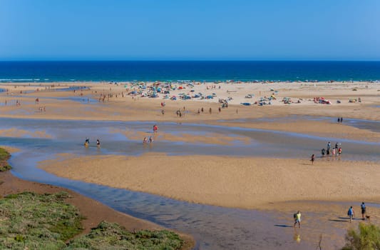 Tavira, Portugal - August 15, 2023: People at the famous beach of Cacela Velha in Tavira. This beach is a part of famous tourist region of Algarve.