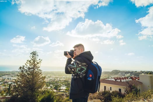 Traveler photographer with digital camera on top of the mountain