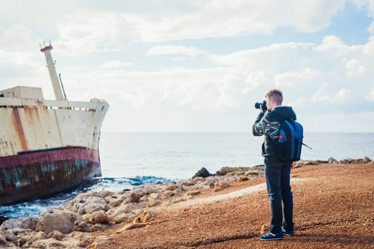 Young handsome male photographer on the beach