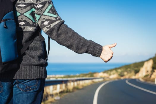 road trip, travel, gesture and people concept - hitchhiker stopping car with thumbs up hand sign.
